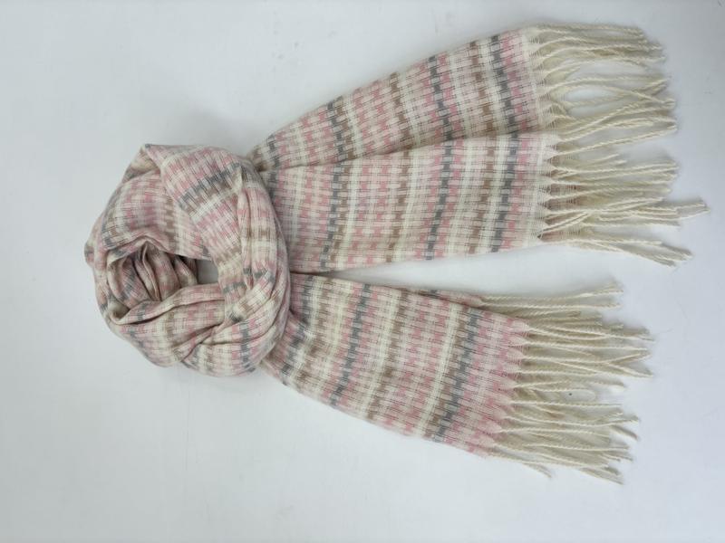 Lightweight woven scarf in cream, pink and grey stripe pattern with twisted fringe ends, loosely draped on white surface