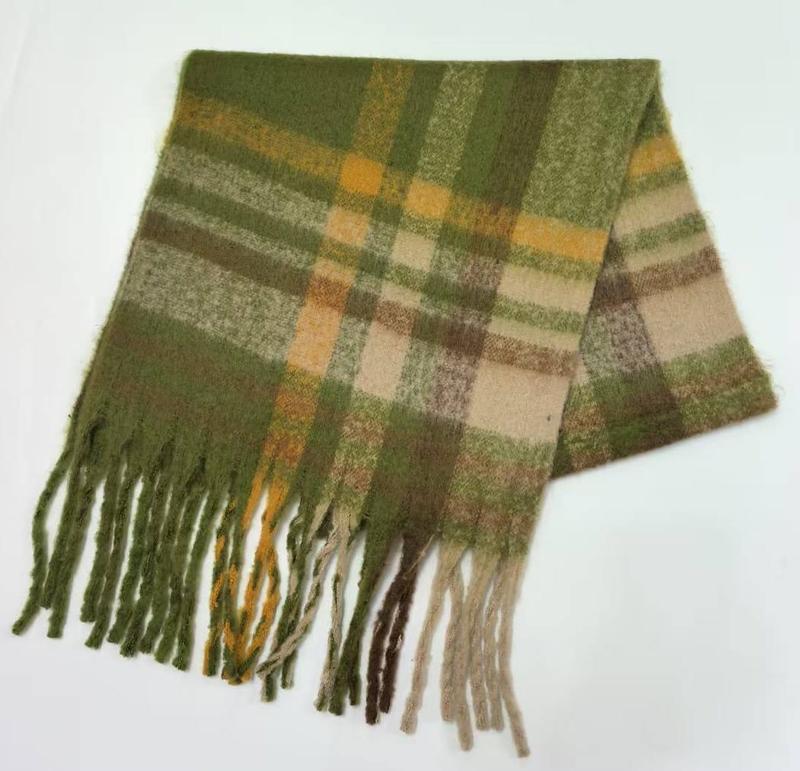 Folded green, gold, and beige plaid wool-blend scarf with twisted fringe tassels on white background
