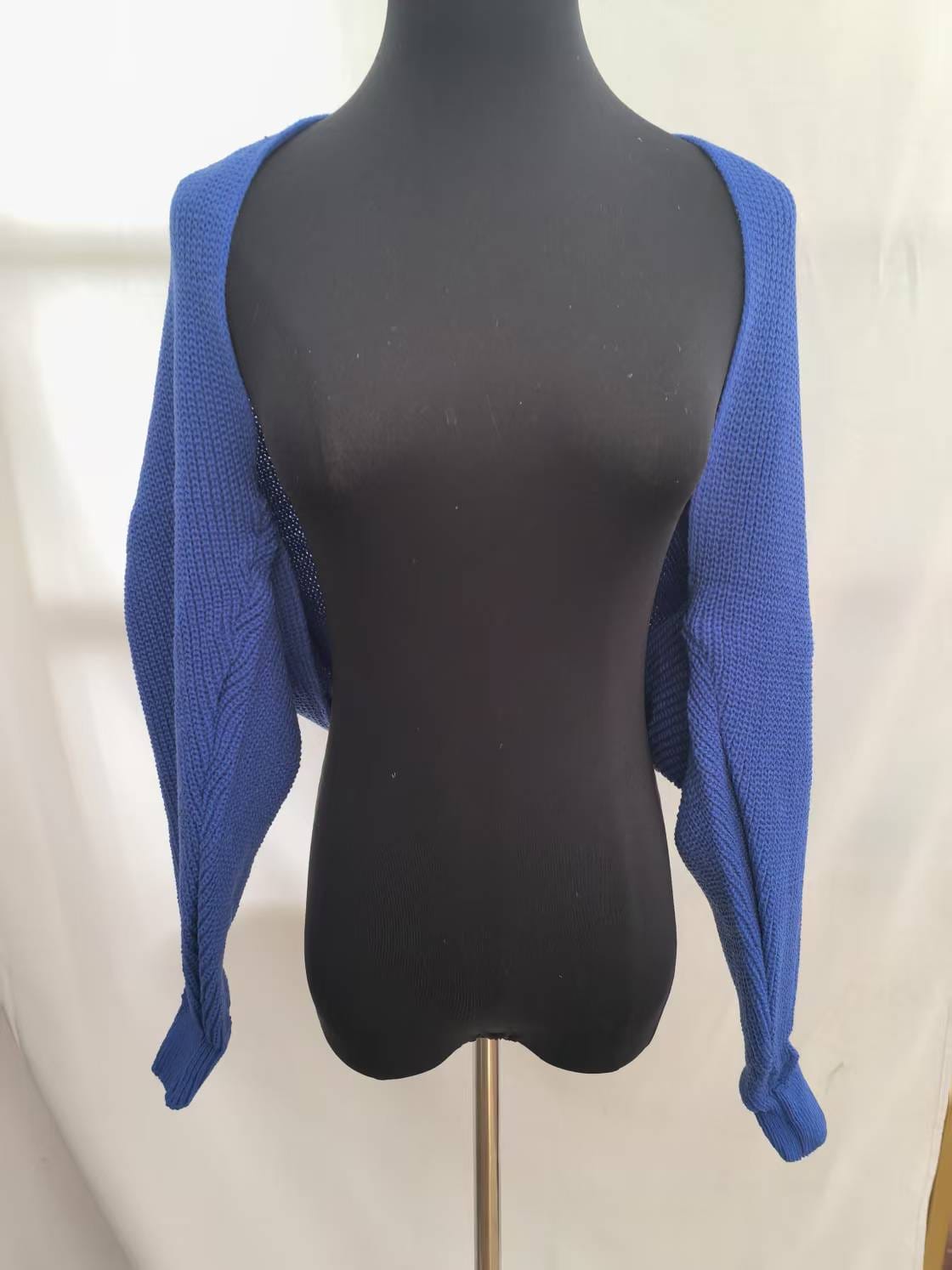 Royal blue chunky knit cropped shrug cardigan with long sleeves displayed on black dress form mannequin