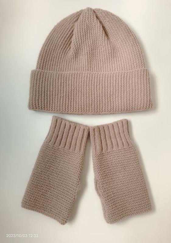 Blush pink chunky knit beanie hat and matching fingerless gloves set laid flat on white background
