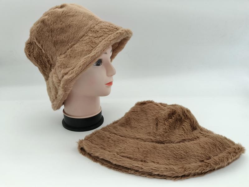 Camel faux fur bucket hat displayed on mannequin head with matching hat laid flat on white surface