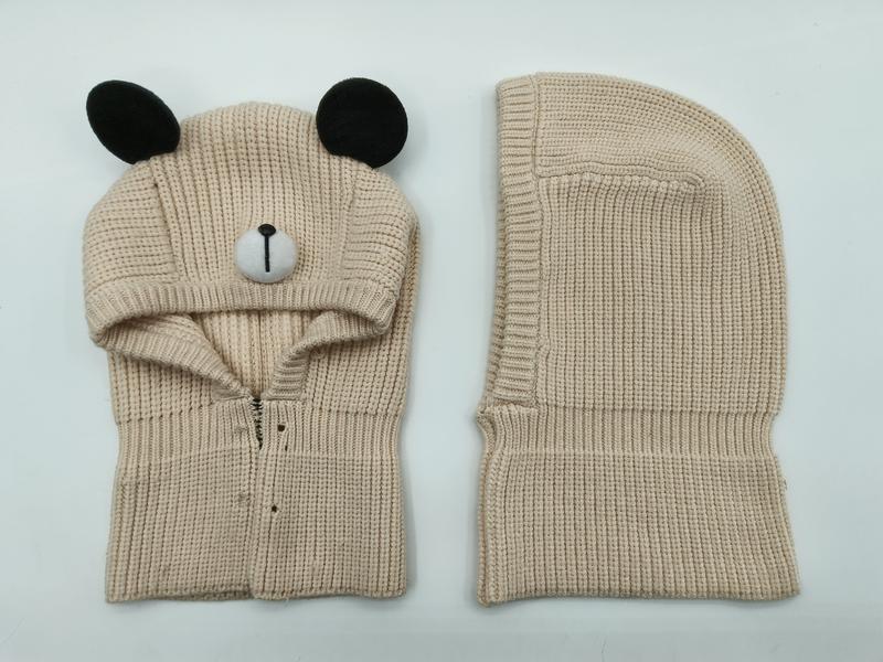 Beige chunky knit bear balaclava with black ears and embroidered nose, shown front and back view on white background