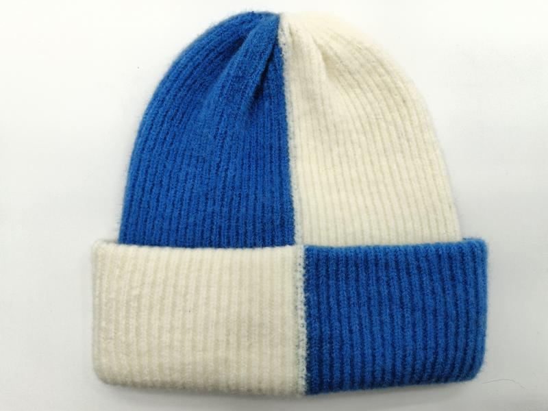 Color-block ribbed knit beanie hat in royal blue and off-white with folded cuff, laid flat on white background