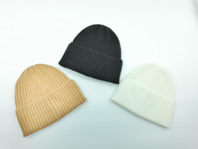 Three ribbed knit beanie hats in black, camel, and ivory displayed on white background, folded cuff style