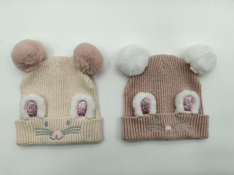 Two children's ribbed knit beanies in cream and taupe with fluffy double pom pom mouse ears and embroidered face detail