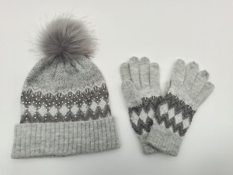 Grey knitted Fair Isle beanie hat with fur pom-pom and pearl embellishments alongside matching knit gloves set