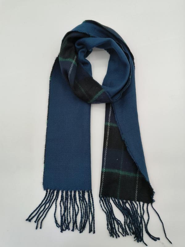 Reversible winter scarf with teal solid side and navy green tartan plaid side, knotted display with tassel fringe ends