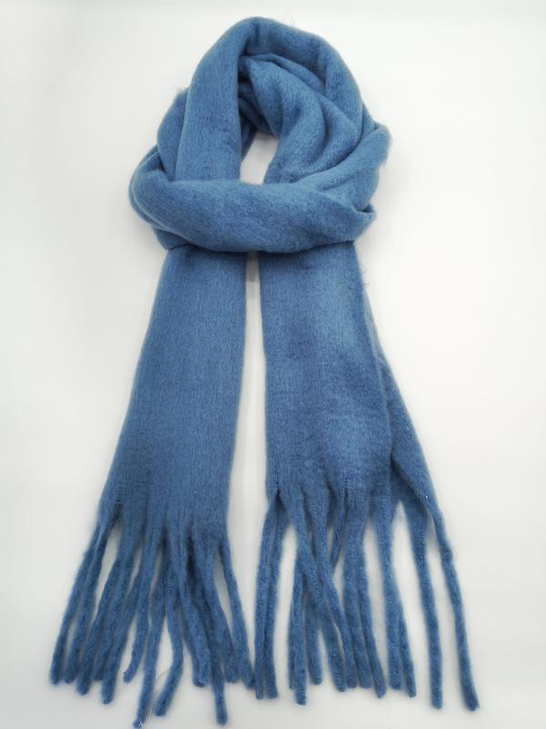 Steel blue soft brushed wool-blend winter scarf tied in a loose knot with long tassel fringe ends on white background