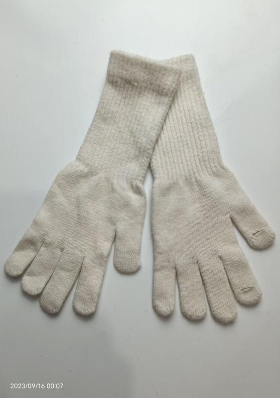Pair of cream off-white ribbed knit full-finger gloves laid flat on white background, showing both palms