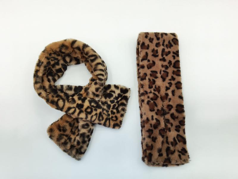 Faux fur leopard print scarf tied in a knot and matching rectangular headband on white background