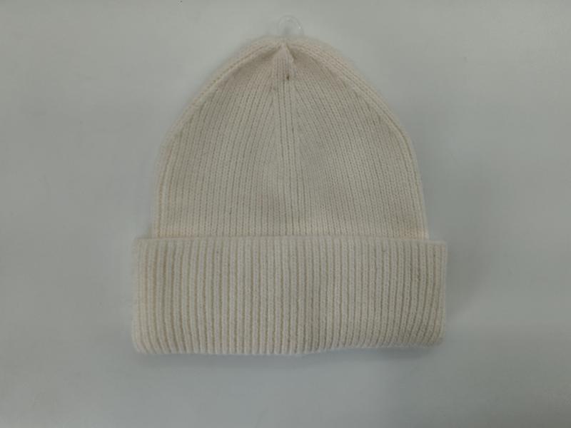Cream off-white ribbed knit beanie hat with folded cuff displayed flat on light gray background