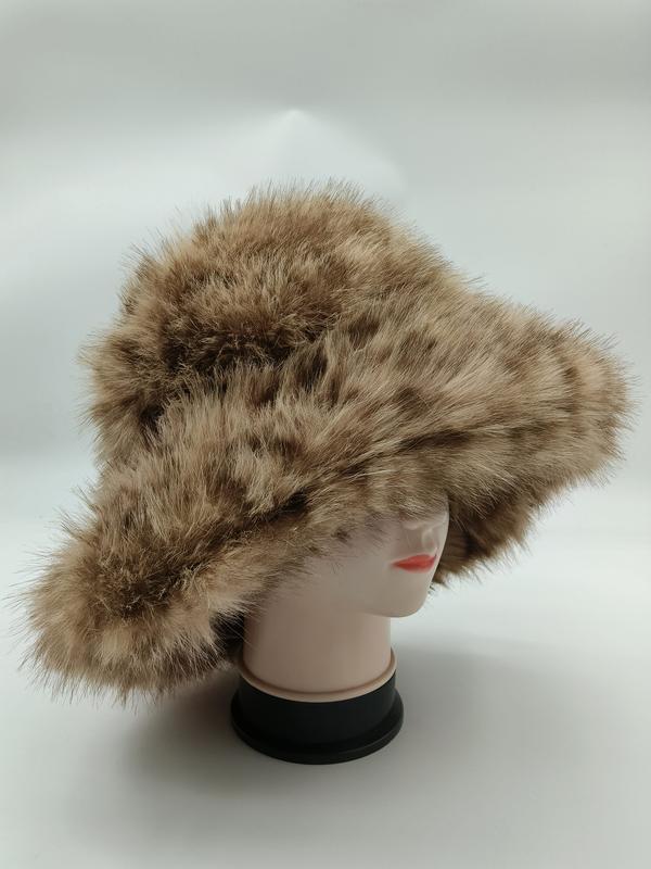Tan and brown spotted faux fur wide brim bucket hat displayed on a white mannequin head against a light background