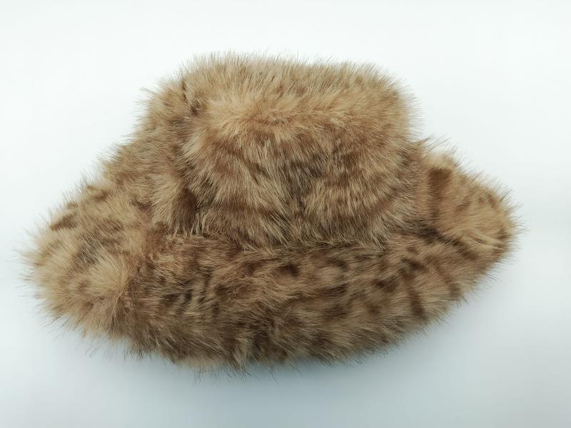 Tan and brown spotted faux fur wide brim bucket hat with fluffy texture on white background