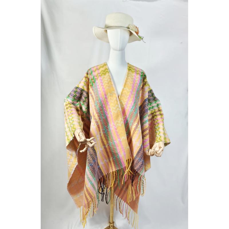 Mannequin wearing a multicolor chevron zigzag woven fringe shawl poncho with white sun hat on white background