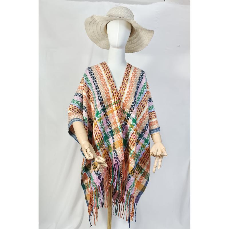 Mannequin wearing multicolor geometric patterned woven fringe poncho cape with wide-brim hat, boho style