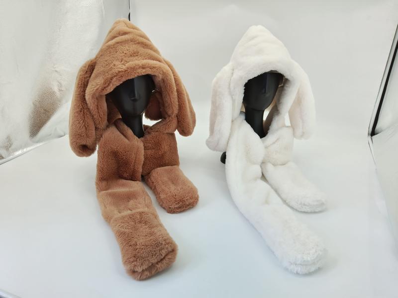 Two faux fur hooded scarf sets with long bunny ears on mannequins, one brown and one white, displayed on white surface