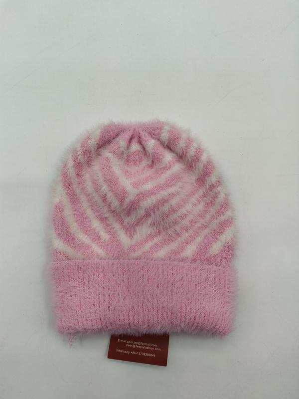 Pink and white fuzzy knit beanie hat with geometric chevron stripe pattern and folded cuff, laid flat on white background