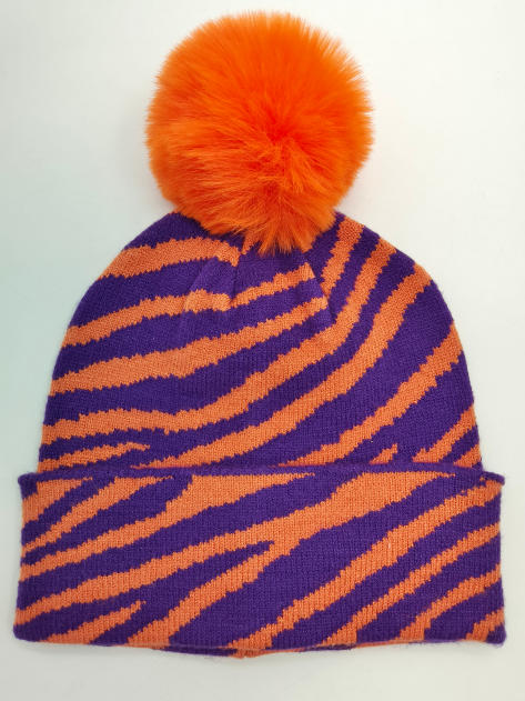 Knit beanie hat with purple and orange zebra stripe pattern and large orange faux fur pompom on top