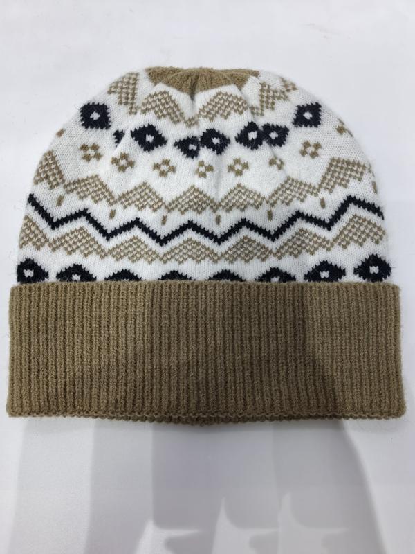 Folded Fair Isle knit winter beanie hat with tan ribbed cuff, white body, navy and tan chevron zigzag and floral pattern