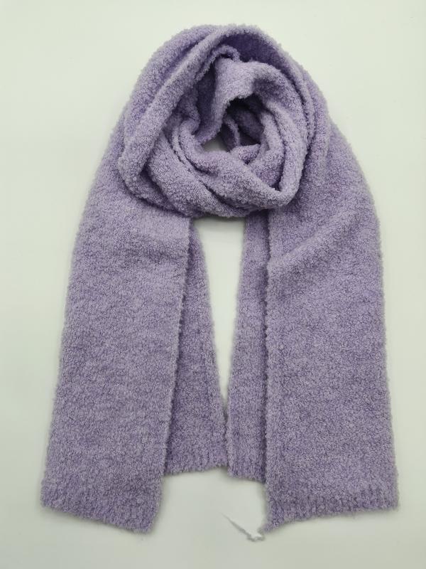 Soft lavender purple boucle knit scarf loosely coiled on white background, showing fluffy textured weave and ribbed ends