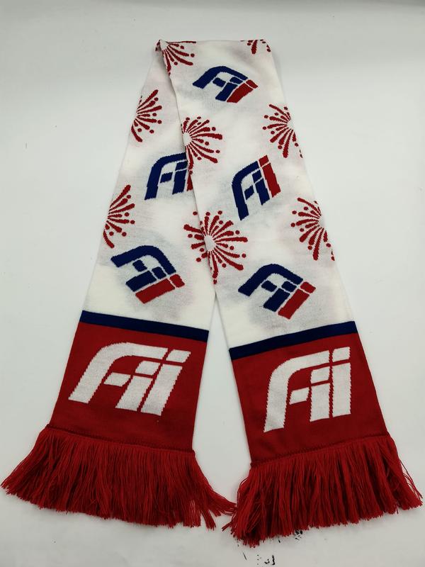 Knitted fan scarf in red, white and blue with repeated logo and firework motifs, red fringe ends laid flat on white background